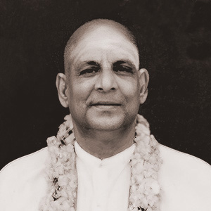 Sivananda sitting having been garlanded by a devotee