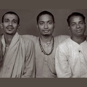 Swami Venkatesananda with his arms holding his borther disciples close, Swami Chidananda, on the left and Swami Saswathananda on the right). 