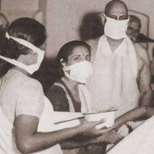 Former doctor, Swami Sivananda, stands in the operating room along with doctors and nurses to observe the proceedure
