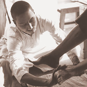 Swami Venkatesananda washes the feet of his Master, Swami Sivananda