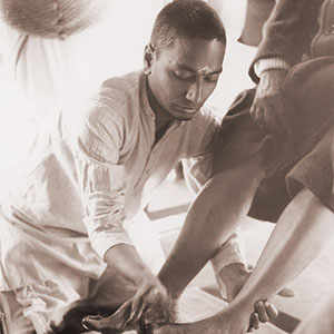 Swami Venkatesananda washes the feet of his Master, Swami Sivananda